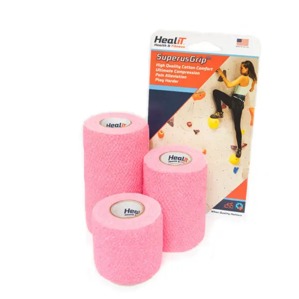 Three rolls of pink compression wrap medical tape are shown in front of a HealIT SuperusGrip package featuring a person climbing an indoor rock wall.